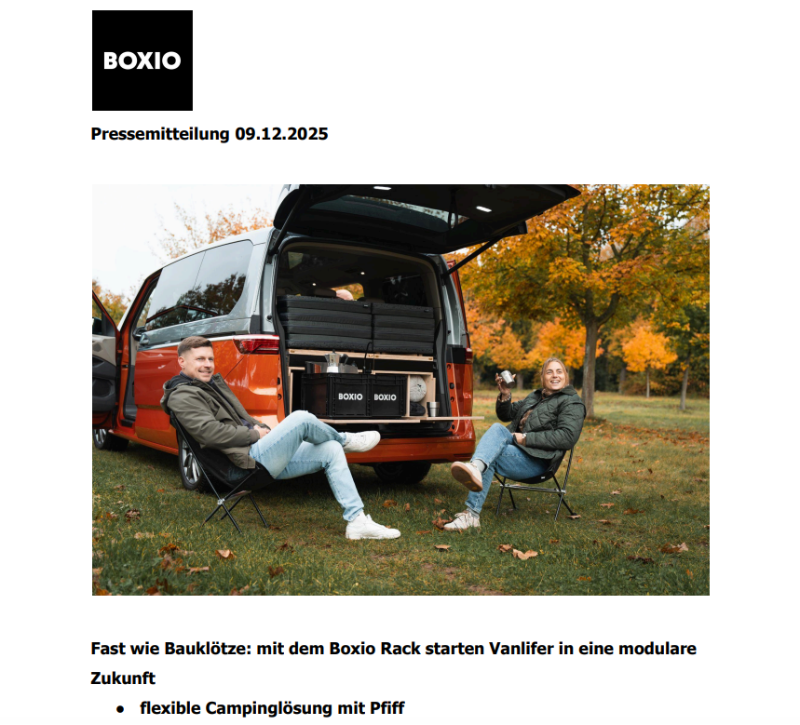 Zwei Personen sitzen entspannt neben einem Campingbus mit offenem Heck, das Boxio Rack sichtbar im Innenraum.
